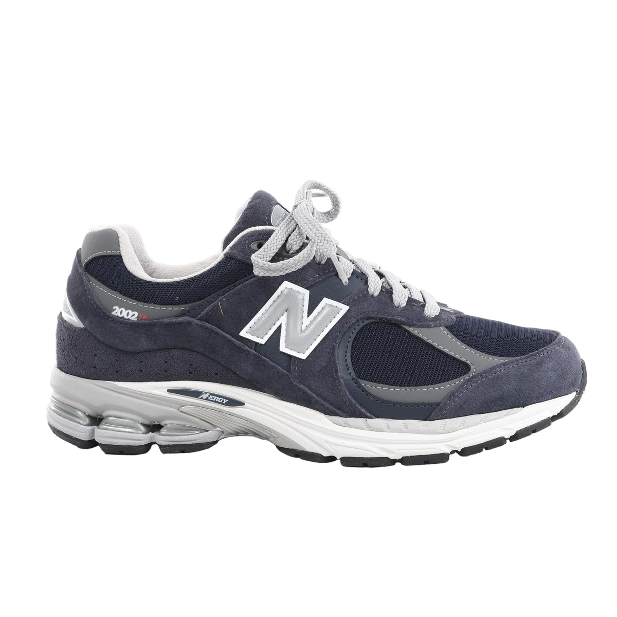 Side view of a navy New Balance sneaker with suede overlays, mesh panels, grey trim and laces, a silver-tone N logo and a white and grey sole.