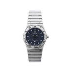 Omega Constellation stainless steel watch with navy blue dial, Roman numeral bezel, baton hour markers, black hands and integrated bracelet on white background.