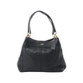 Coach Lexy black pebbled leather shoulder bag with gold-tone hardware, double shoulder straps, Coach logo, and hanging leather tag on white background