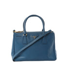 Blue Prada Galleria Saffiano leather handbag with double top handles, gold-tone triangle logo plaque, zip-top closure, and detachable shoulder strap