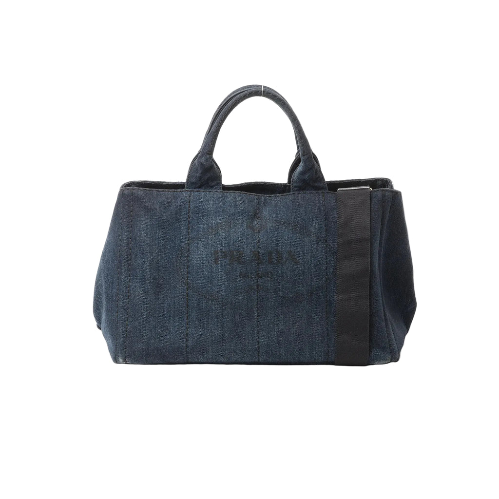 Blue Prada Canapa denim tote handbag with double top handles, wide fabric shoulder strap, and tonal Prada logo on the front