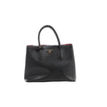 Front view of Prada Cuir black Saffiano leather handbag with twin rounded handles, red edging and a gold-tone triangular Prada logo.
