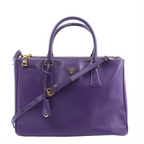 Prada Galleria handbag in purple Saffiano leather with rolled top handles, detachable shoulder strap, gold-tone hardware and triangle logo.
