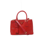 Front view of Prada Galleria red Saffiano Lux leather handbag with twin top handles, matching shoulder strap, triangular Prada logo and gold-tone hardware.