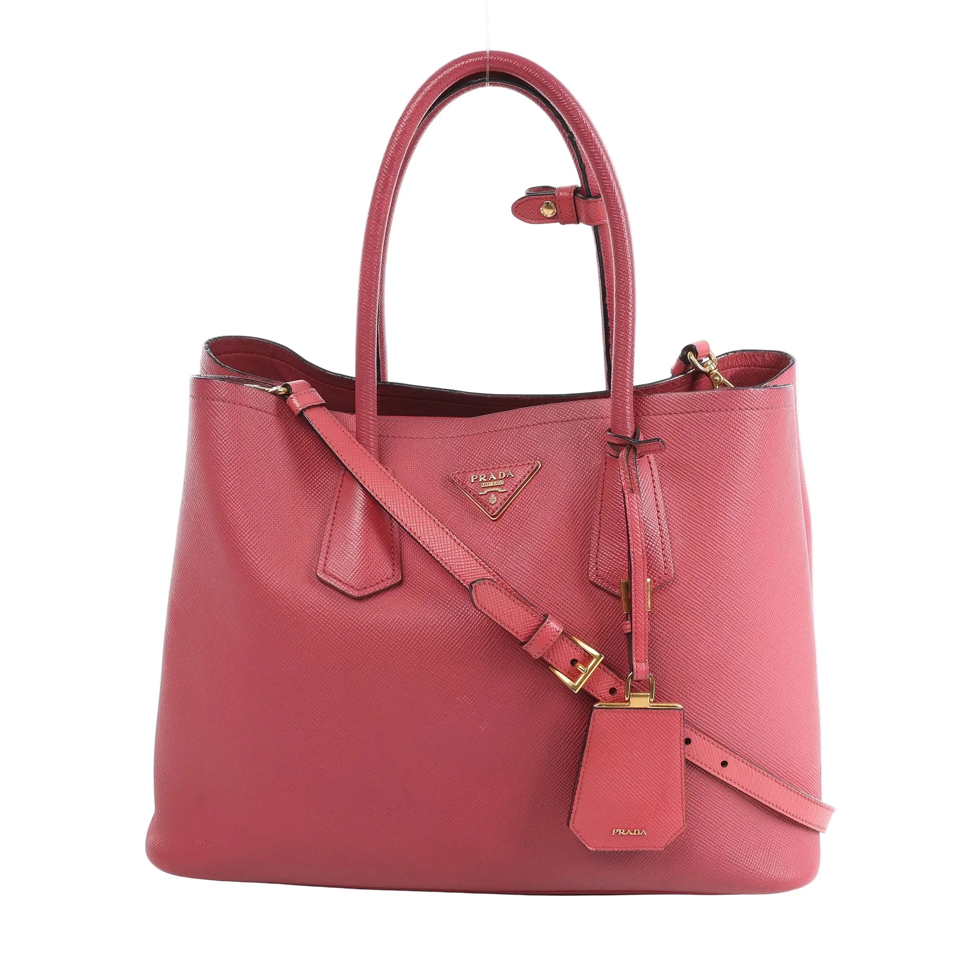 Prada Cuir Saffiano Lux 2Way handbag in pink textured leather with gold-tone hardware, dual top handles, detachable crossbody strap, and leather ID tag.