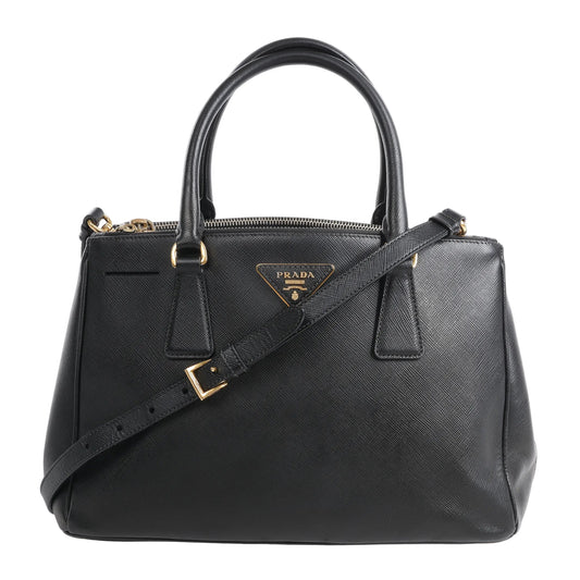Prada Galleria Saffiano Lux Leather 2Way Handbag in black, featuring textured leather, gold-tone hardware, top handles, detachable shoulder strap, and signature Prada triangle logo plaque on the front.