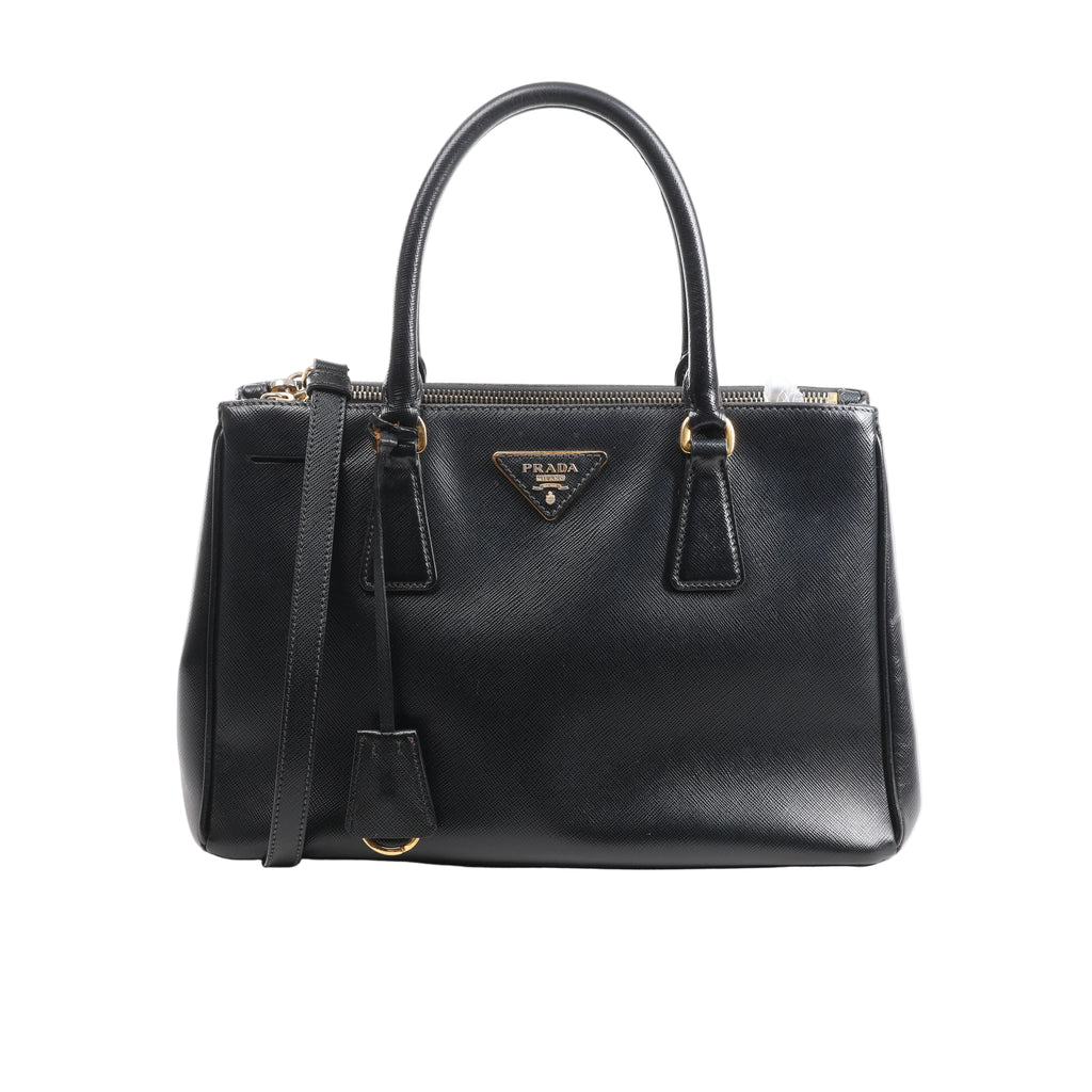 Black Prada Galleria Saffiano leather handbag with double top handles, detachable shoulder strap, gold-tone hardware and triangle logo plaque.