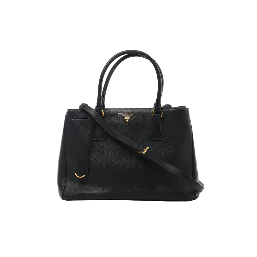 Front view of Prada Galleria black Saffiano leather handbag with twin top handles, matching shoulder strap, triangular Prada logo and gold-tone hardware.