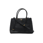 Front view of Prada Galleria black Saffiano leather handbag with twin top handles, matching shoulder strap, triangular Prada logo and gold-tone hardware.
