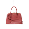 Front view of a pink Prada Promenade Saffiano leather handbag with twin top handles, a shoulder strap, gold-tone hardware and a triangular Prada logo.