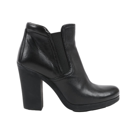 Prada Sport 3TP022 black leather ankle boot in Size 38 EU, featuring a rounded toe, elastic side gore panels, and a sturdy block heel, displayed in profile against a white background.