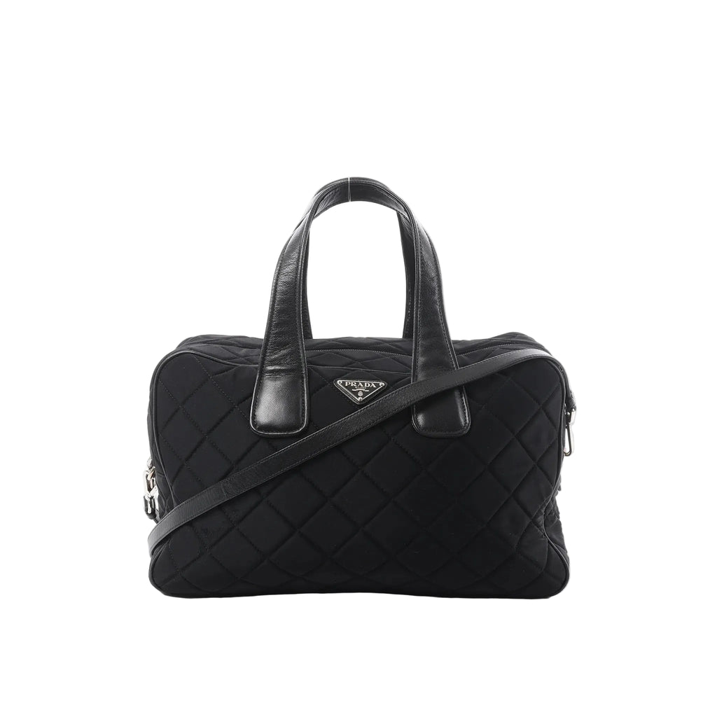 Prada black quilted nylon handbag with leather top handles, detachable shoulder strap, zip closure, and triangular Prada logo plaque on a white background.