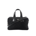 Prada black quilted nylon handbag with leather top handles, detachable shoulder strap, zip closure, and triangular Prada logo plaque on a white background.