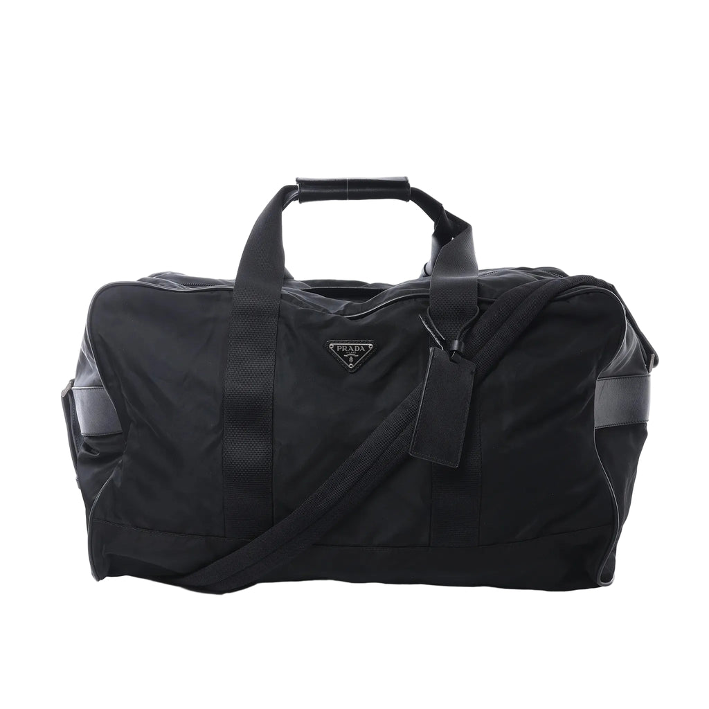 Front view of Prada black Tessuto nylon duffel bag with webbing handles, detachable shoulder strap, leather trim panels, and Prada triangle logo plaque.