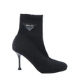 Black Prada sock ankle boot with stretch fabric upper, ribbed cuff, pointed toe, slim stiletto heel and triangle logo plaque.