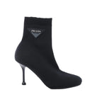 Black Prada sock ankle boot with stretch fabric upper, ribbed cuff, pointed toe, slim stiletto heel and triangle logo plaque.