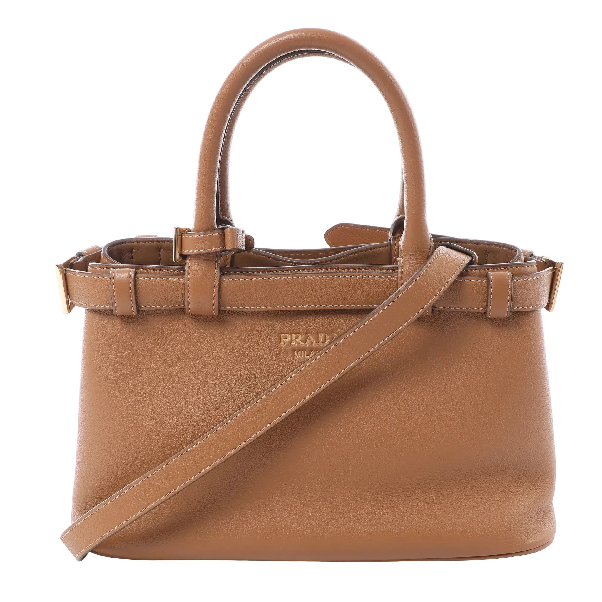 Prada small brown soft-grain leather 2-way handbag with top handles, detachable shoulder strap, buckle strap details, gold-tone hardware, and embossed Prada Milano logo on white background.