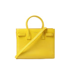 Yellow Saint Laurent Sac de Jour Nano leather tote with structured shape, double top handles, and detachable shoulder strap