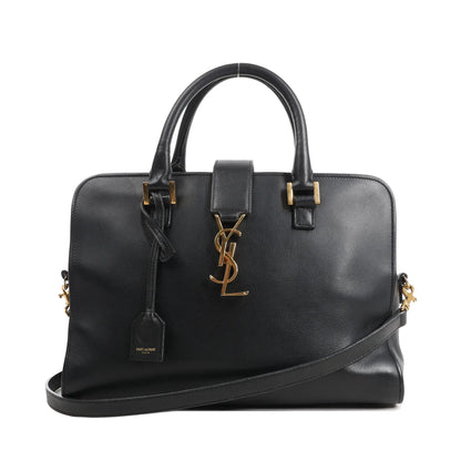 Saint Laurent Monogram Cabas black leather handbag with gold YSL logo, top handles, and detachable shoulder strap.