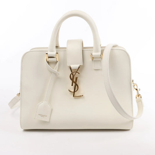 Front view of the Saint Laurent Paris Monogram Cabas Leather 2Way Handbag 472466 in white, showcasing smooth leather exterior, gold YSL logo hardware, top handles, detachable shoulder strap, and matching leather clochette, displayed against a white background.