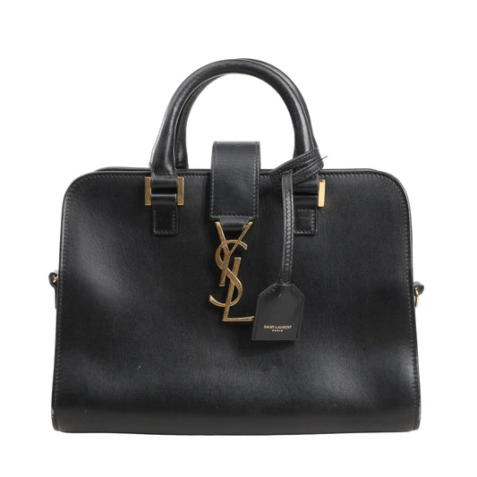 Saint Laurent Paris Baby Cabas handbag in smooth black leather with structured top handles, gold YSL logo hardware, and leather luggage tag.