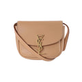 Beige Saint Laurent Kaia leather shoulder bag with curved flap, slim strap and gold-tone YSL monogram clasp.