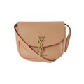 Beige Saint Laurent Kaia leather shoulder bag with curved flap, slim strap and gold-tone YSL monogram clasp.