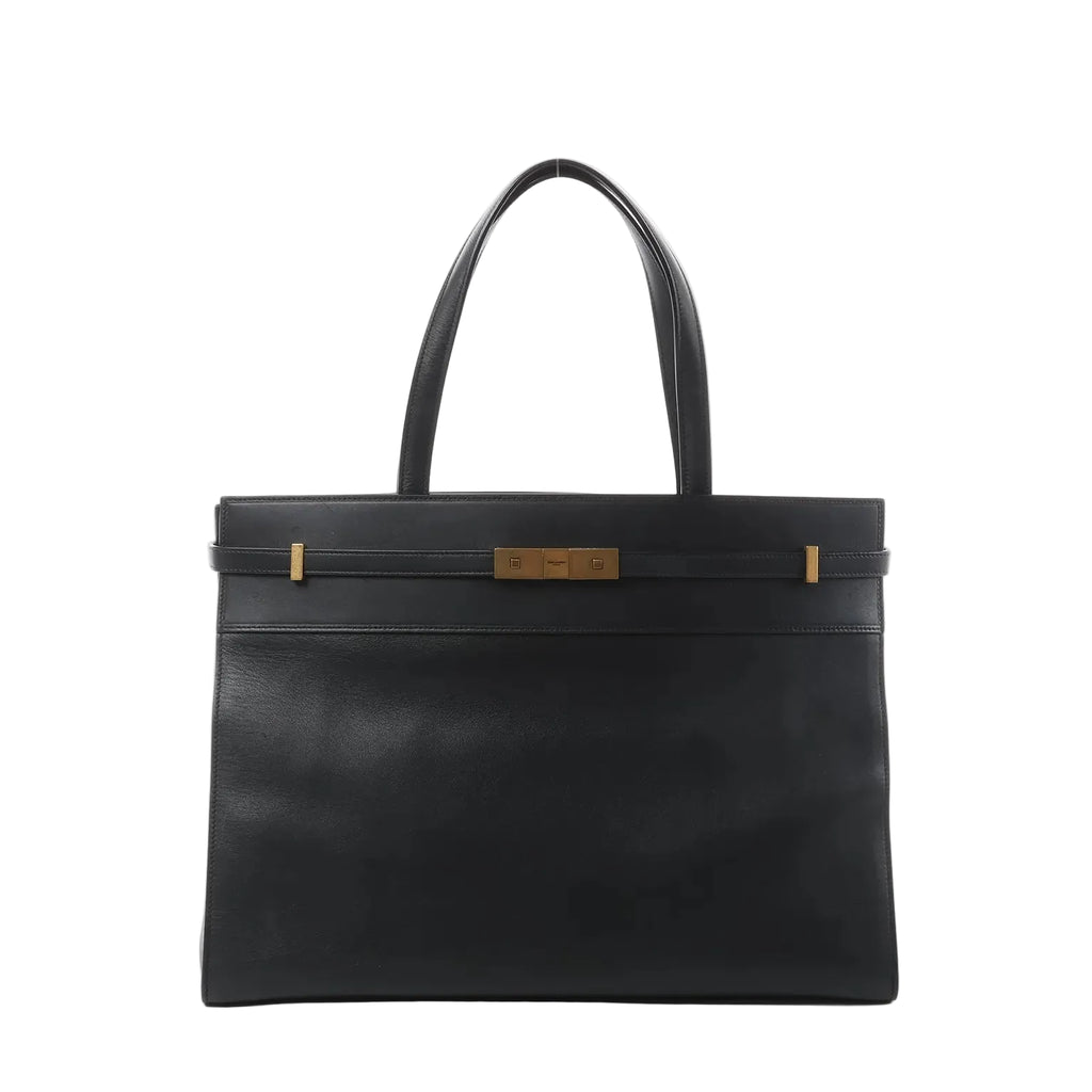 Front view of Saint Laurent Manhattan shoulder bag in black leather with double top handles, structured rectangular shape, and gold-tone strap-and-clasp detail.