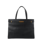 Front view of Saint Laurent Manhattan shoulder bag in black leather with double top handles, structured rectangular shape, and gold-tone strap-and-clasp detail.