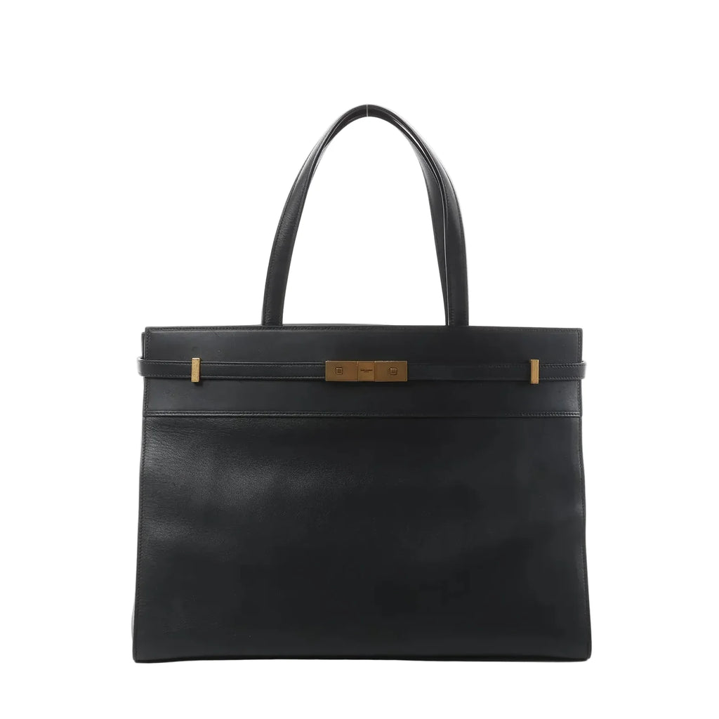 Front view of Saint Laurent Manhattan shoulder bag in black leather with double top handles, structured rectangular shape, and gold-tone strap-and-clasp detail.