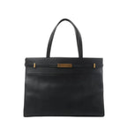 Front view of Saint Laurent Manhattan shoulder bag in black leather with double top handles, structured rectangular shape, and gold-tone strap-and-clasp detail.