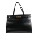 Front view of Saint Laurent Paris Manhattan Tote Bag in black smooth leather, featuring structured silhouette, slim leather strap detail, gold-tone square clasp, and dual leather shoulder handles.