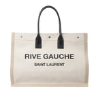 Front view of Saint Laurent Rive Gauche Large Tote Bag 499290 in beige canvas with black printed logo text, black leather top handles, and silver-tone hardware, displayed against a white background.