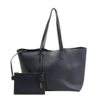 Front view of the Saint Laurent Paris Shopping Bag 394195 in navy blue leather, featuring long flat handles, minimal branding, and a matching detachable zip pouch with gold YSL charm.