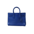 Saint Laurent Sac de Jour structured handbag in blue smooth leather with dual top handles, hanging leather clochette and clean minimalist design.