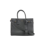 Gray Saint Laurent Sac de Jour Small grainy leather handbag with double top handles, shoulder strap, gold-tone hardware and front logo.