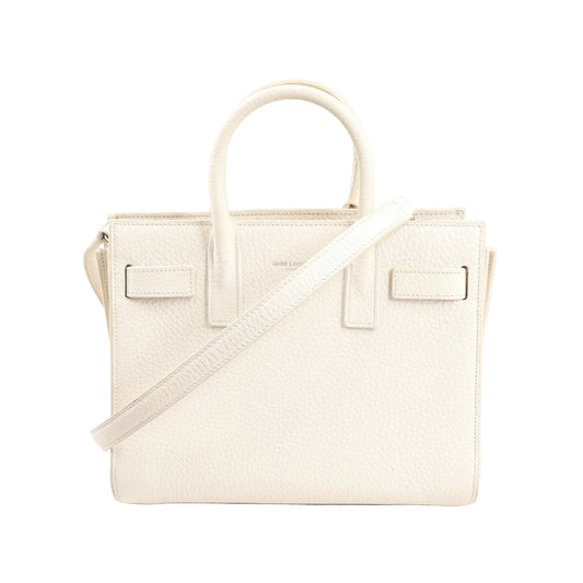 Saint Laurent Sac de Jour Nano handbag in white grained leather featuring dual top handles, detachable shoulder strap, and structured silhouette with minimal branding.
