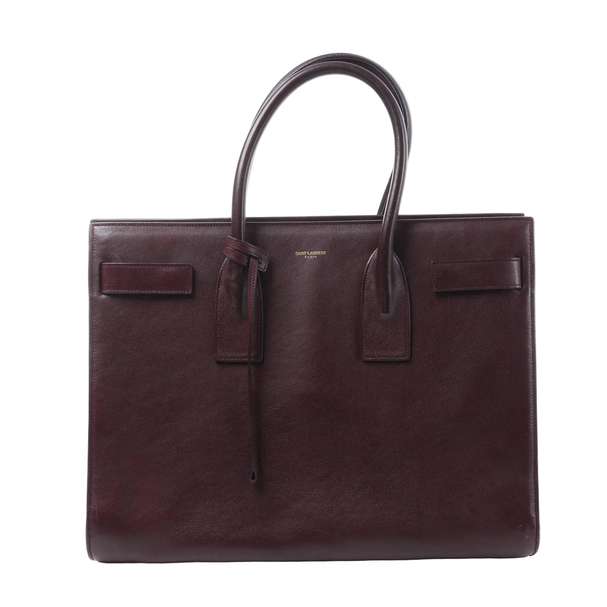 Saint Laurent Sac de Jour handbag in burgundy leather with rolled top handles, structured rectangular shape and belted side details.