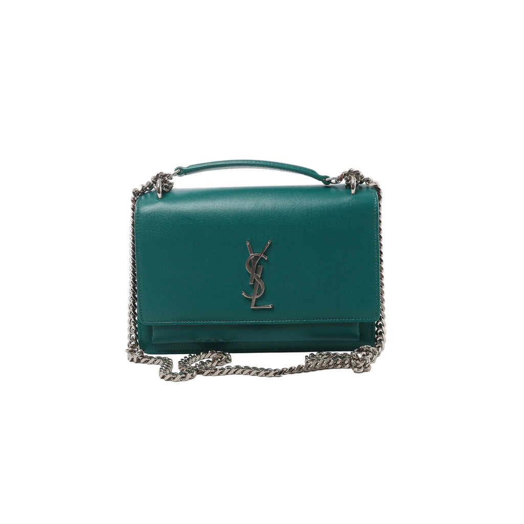 Front view of Saint Laurent Sunset green leather flap bag with a silver-tone YSL monogram and chain strap with a matching leather shoulder section.