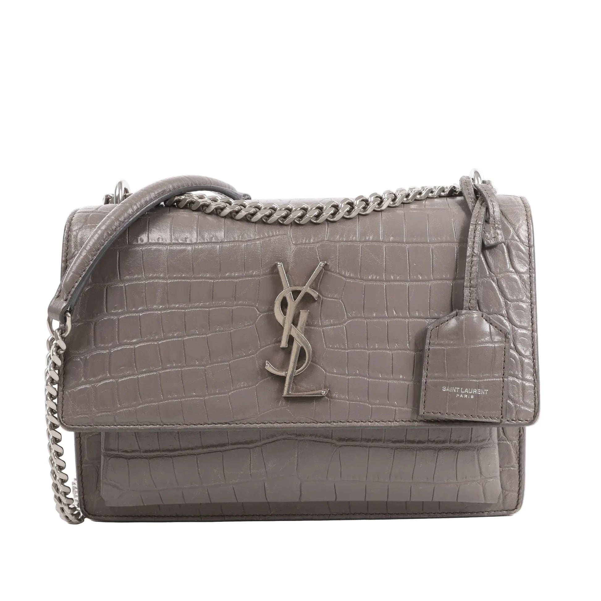 Front view of the Saint Laurent Paris Sunset Medium Mock Croc Shoulder Bag in gray, showcasing embossed crocodile-textured leather, silver-tone YSL logo hardware, chain shoulder strap, and leather tag detail, set against a white background.