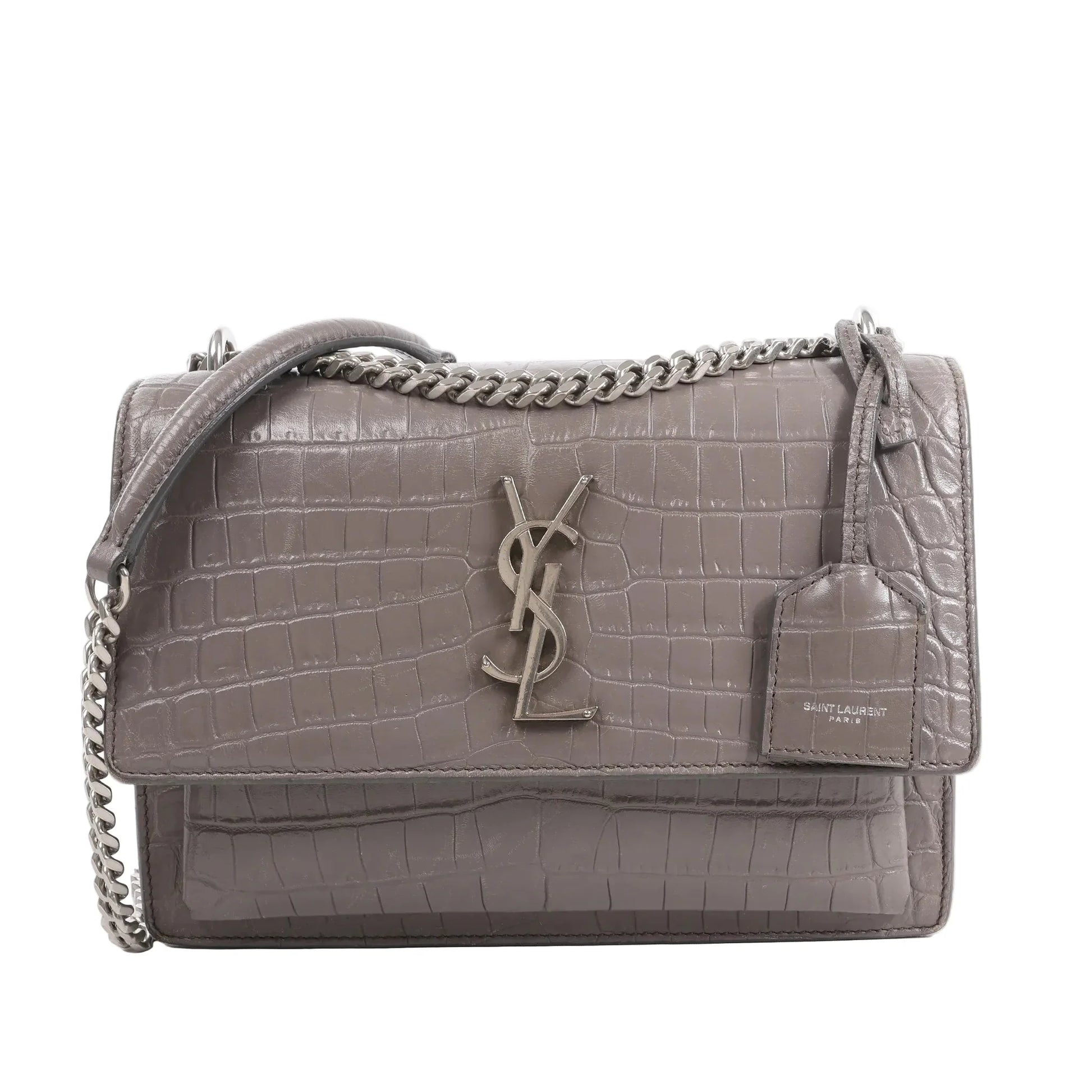 Front view of the Saint Laurent Paris Sunset Medium Mock Croc Shoulder Bag in gray, showcasing embossed crocodile-textured leather, silver-tone YSL logo hardware, chain shoulder strap, and leather tag detail, set against a white background.