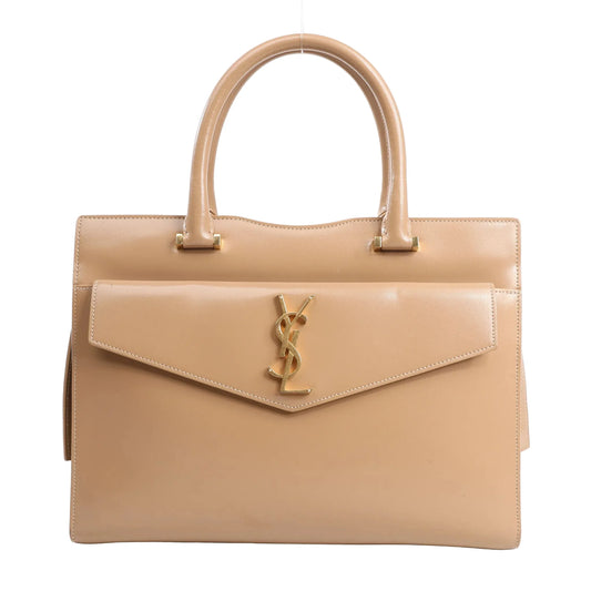 Saint Laurent Paris Uptown leather handbag in beige featuring a structured silhouette, top handles, front flap with gold YSL logo hardware, and smooth leather finish.