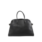 Black The Row Soft Margaux 15 leather handbag with rounded top, double top handles, and small side buckle details with gold-tone hardware.
