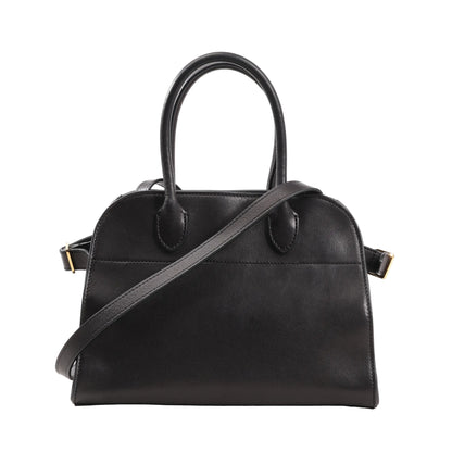 Front view of The Row Soft Margaux 10 handbag in black smooth leather featuring a structured yet soft silhouette, dual top handles, and a detachable shoulder strap with gold-tone hardware.