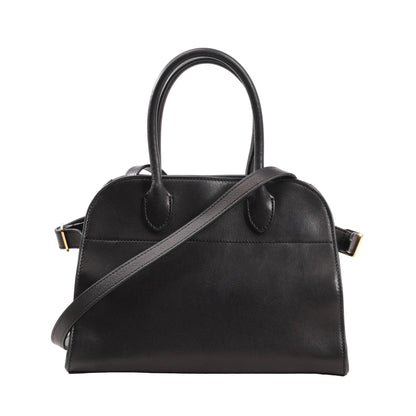 Front view of The Row Soft Margaux 10 handbag in black smooth leather featuring a structured yet soft silhouette, dual top handles, and a detachable shoulder strap with gold-tone hardware.