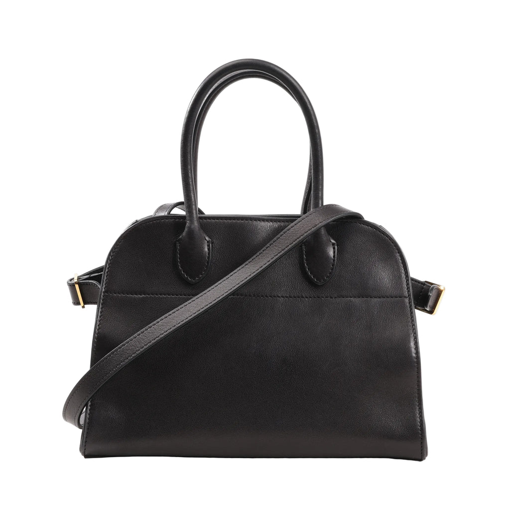 Front view of The Row Soft Margaux 10 handbag in black smooth leather featuring a structured yet soft silhouette, dual top handles, and a detachable shoulder strap with gold-tone hardware.