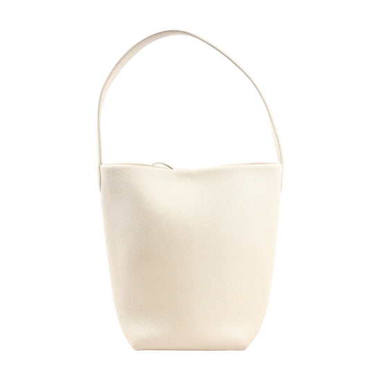 The Row Park Tote Small shoulder bag in ecru grained leather featuring a curved, unstructured silhouette, single wide strap, and minimalist design without visible hardware.