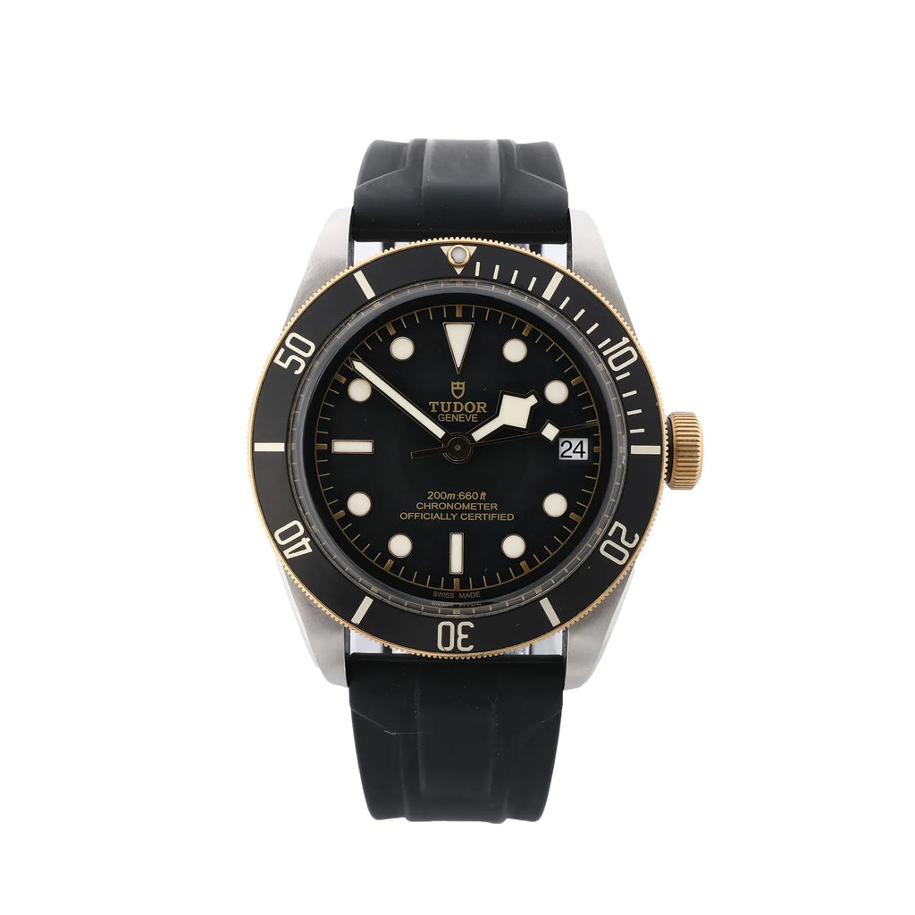Front view of Tudor Black Bay S&G watch with black rubber strap, black dial with luminous hour markers, snowflake hands, black bezel with minute scale, gold-tone crown, and date window at 3.