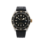 Front view of Tudor Black Bay S&G watch with black rubber strap, black dial with luminous hour markers, snowflake hands, black bezel with minute scale, gold-tone crown, and date window at 3.