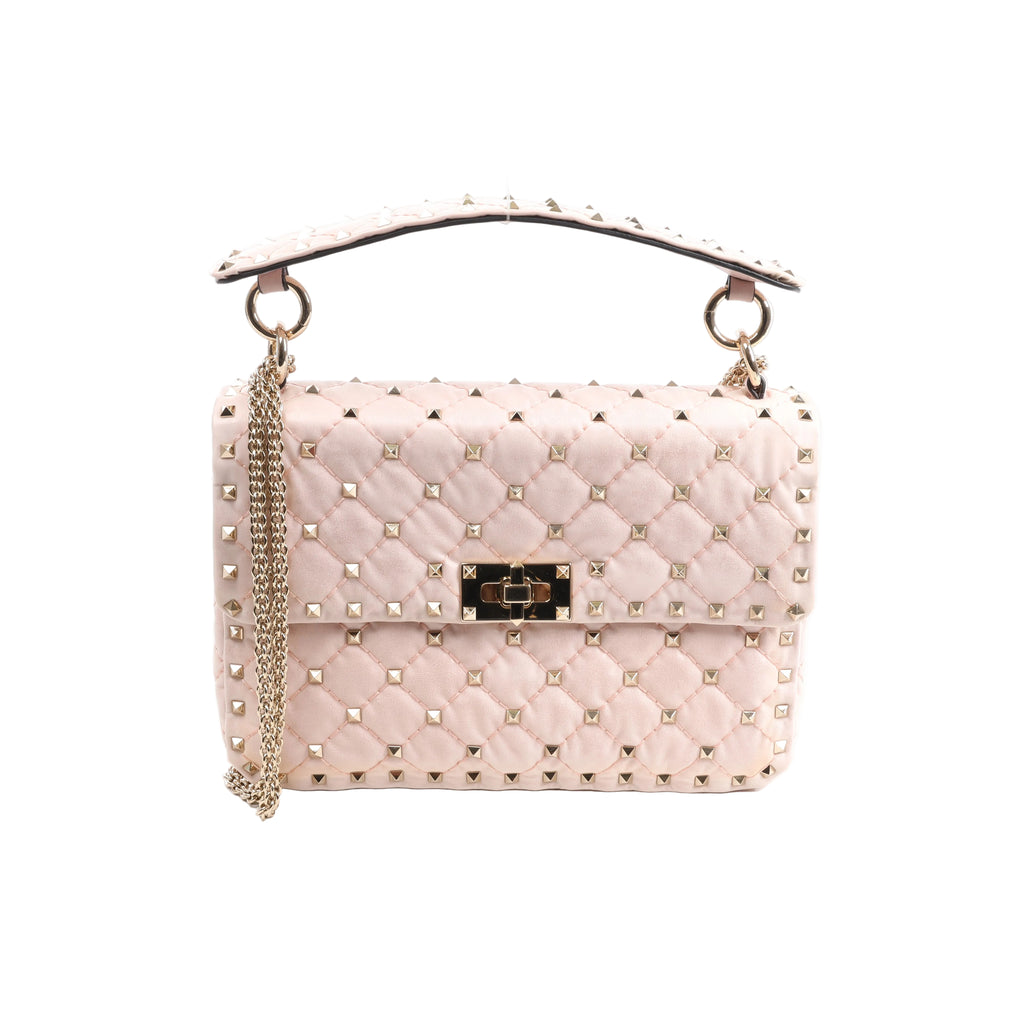 Pink Valentino Garavani Rockstud Spike leather bag with diamond quilting, pyramid studs, studded top handle, chain strap and turn-lock closure.